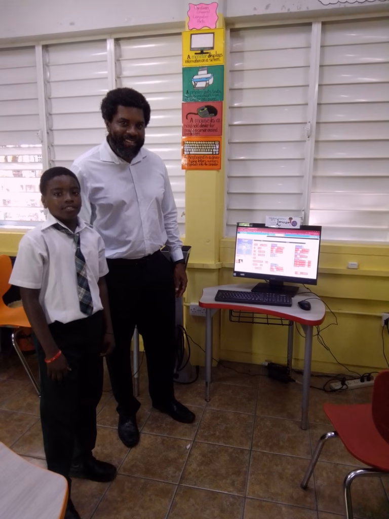 NTRC Exec Dir Craig Nesty with Student in Soufriere Primary School Computer Lab