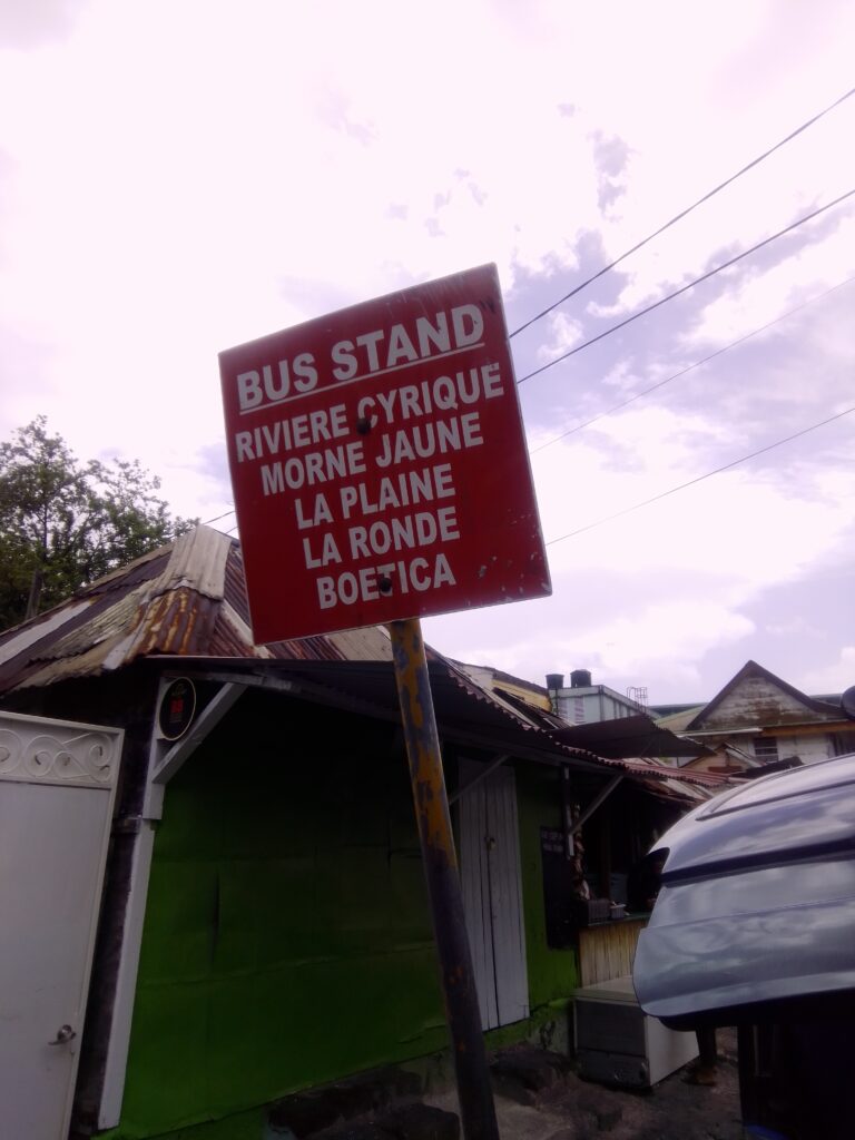 A red bus stop sign listing desitinations.